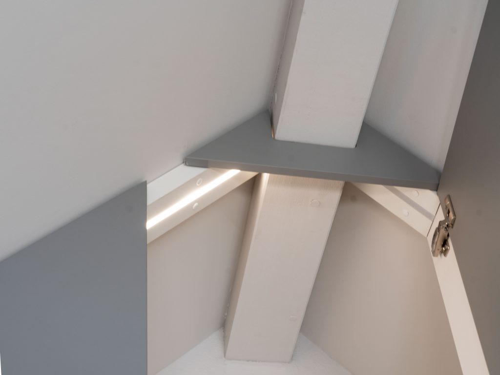 Raumhoher Kleiderschrank in Dachschräge mit automatischer LED-Beleuchtung im Schrankinnern, integrierte Schiebetüre, Kleiderstange, Schubladen- und Tablare